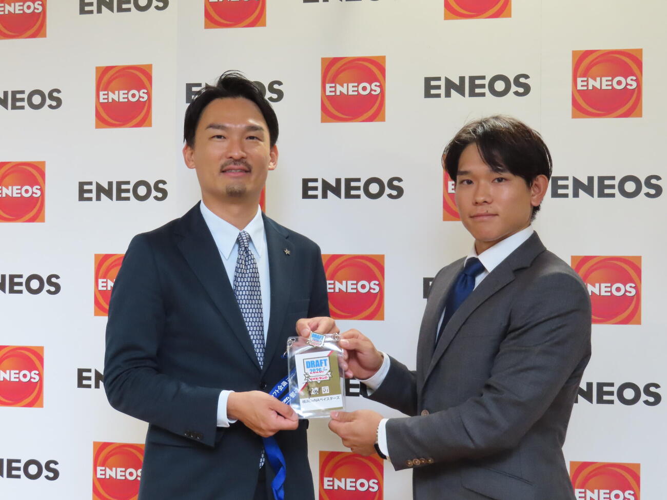 指名あいさつを受けたDeNAドラフト6位のENEOS・神里陸（右）と長谷川竜也編成部長