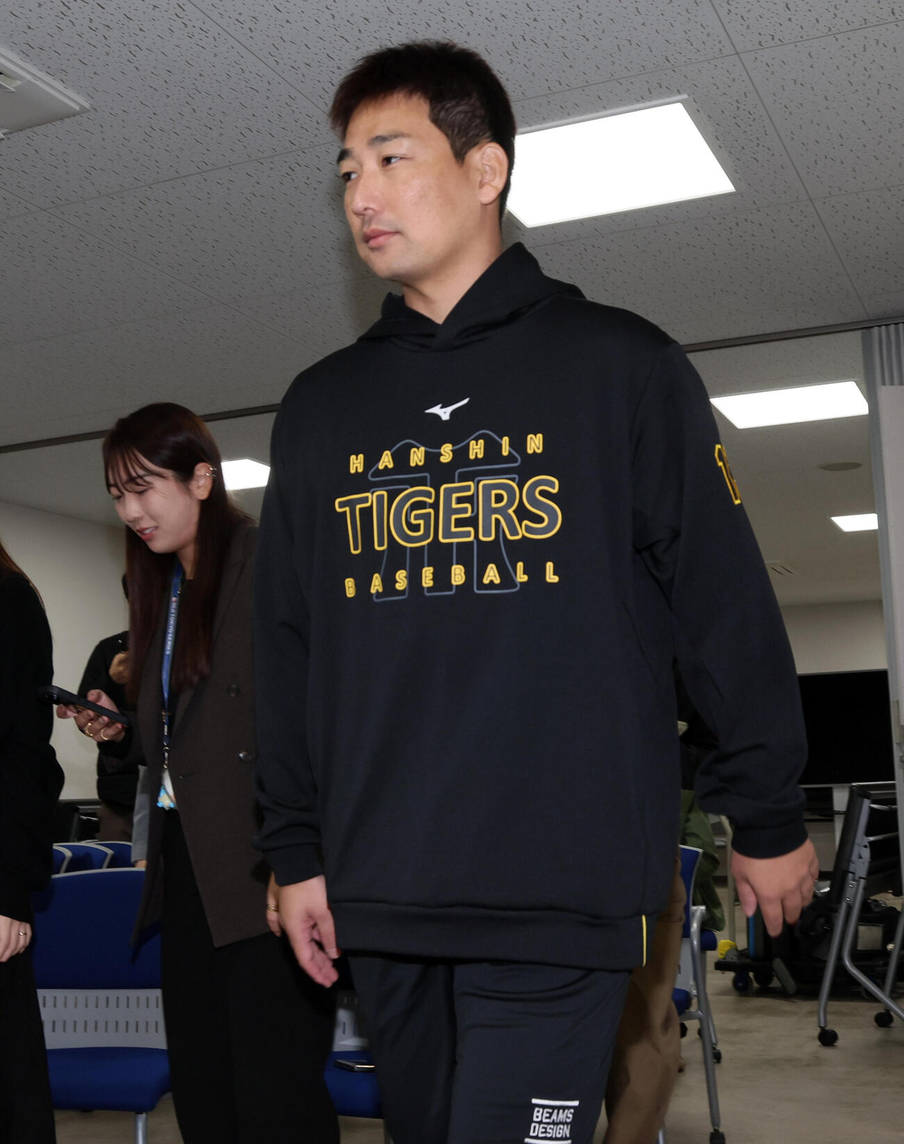 会見場に入る阪神岩崎優（撮影・加藤哉）