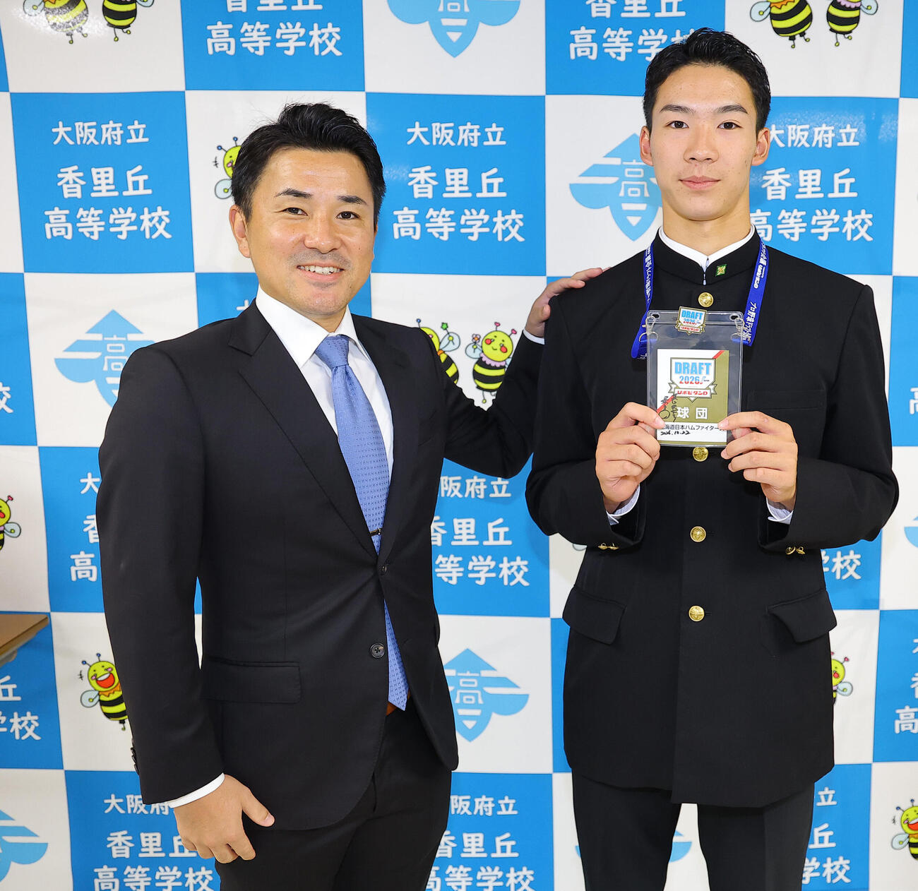 日本ハムドラフト5位の大阪府立香里丘高校・岡本翔斗（右）は河本拓也監督と笑顔を見せる（撮影・上田博志）