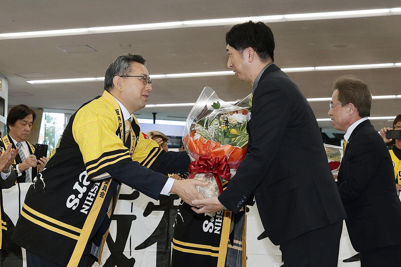 高知龍馬空港に到着し、西内直彦安芸市長（左）から花束を受け取る阪神藤川球児監督（撮影・前田充）