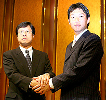 阪神入団を決意した新井（右）は南球団社長と握手する（撮影・浅見桂子）