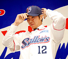 入団発表会見で林昌勇は、ユニホーム姿でヤクルトの帽子をかぶる（撮影・山崎哲司）