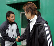 母校に自主トレに現れたロッテ西岡（右）と緊張の面持ちで握手を交わす日本ハム中田（撮影・宇治久裕）
