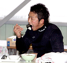 練習後、汗まみれで昼食のおにぎりにかぶりつく中田（撮影・黒川智章）