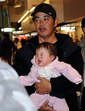 アリゾナの自主トレから帰国した工藤はファンの赤ちゃんを抱いての記念撮影（撮影・柴田隆二）