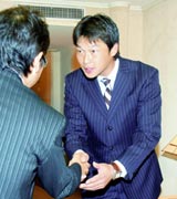 阪神の沼沢正二球団本部長と握手する、広島からＦＡ宣言した新井（代表撮影）