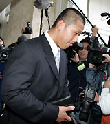 那覇空港で大勢の報道陣に囲まれ、思わず舌を出す中田（撮影・黒川智章）