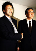契約が合意に達し日本ハム山田ＧＭ（右）と握手する多田野（撮影・野上伸悟）