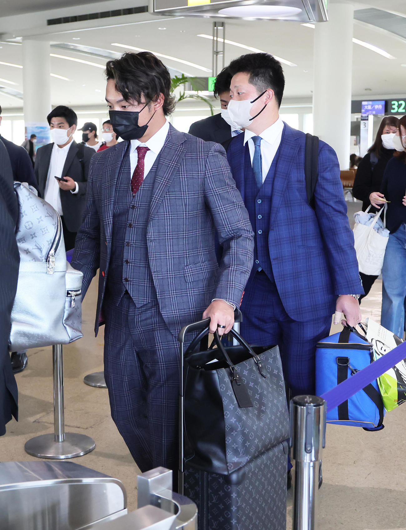 那覇から宮崎へと向かう日本ハム伊藤（左）とDeNA牧（撮影・足立雅史）