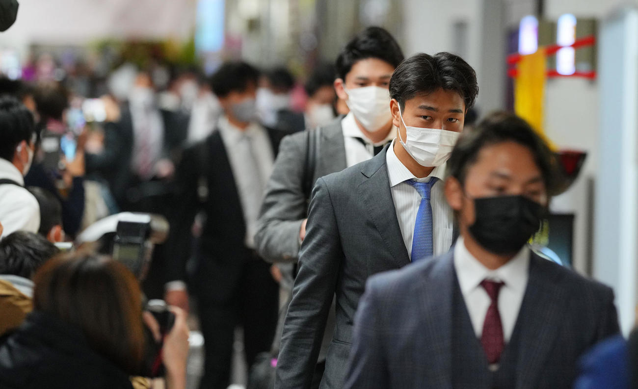 那覇から宮崎空港に到着しファンや報道陣の出迎えを受ける高橋宏（右から2人目）（撮影・垰建太）