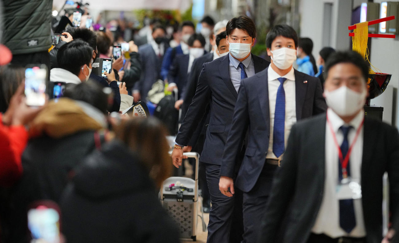 那覇から宮崎空港に到着し多くのファンや報道陣の出迎えを受ける、山田（右から2人目）、村上（同3人目）ら侍ジャパンの選手たち（撮影・垰建太）