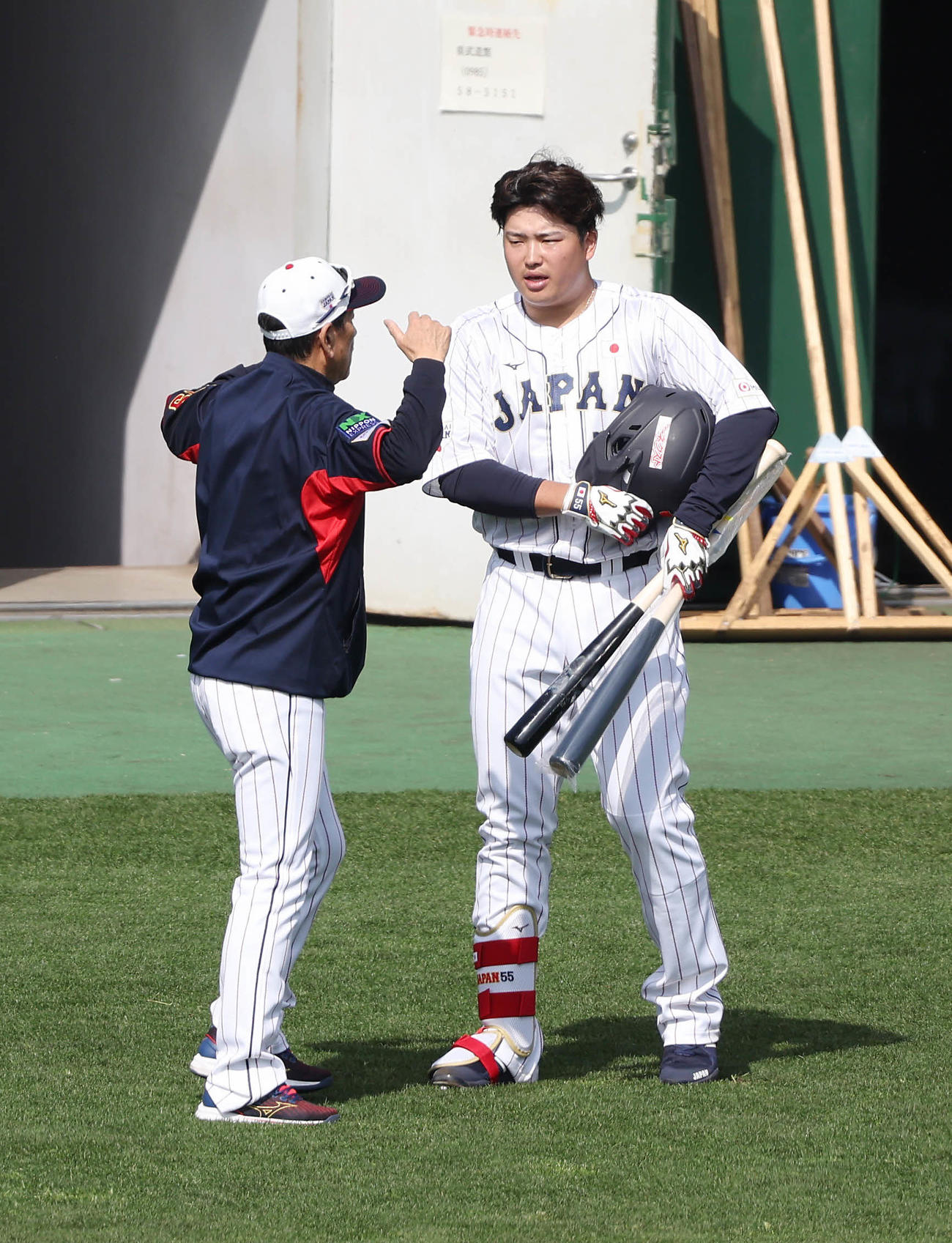 フリー打撃を終え、栗山監督（左）と言葉を交わす村上（撮影・前田充）