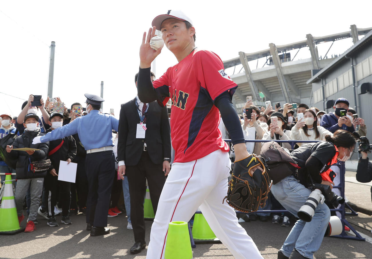 ファンに手を振りながら練習場を移動する山本（撮影・前田充）