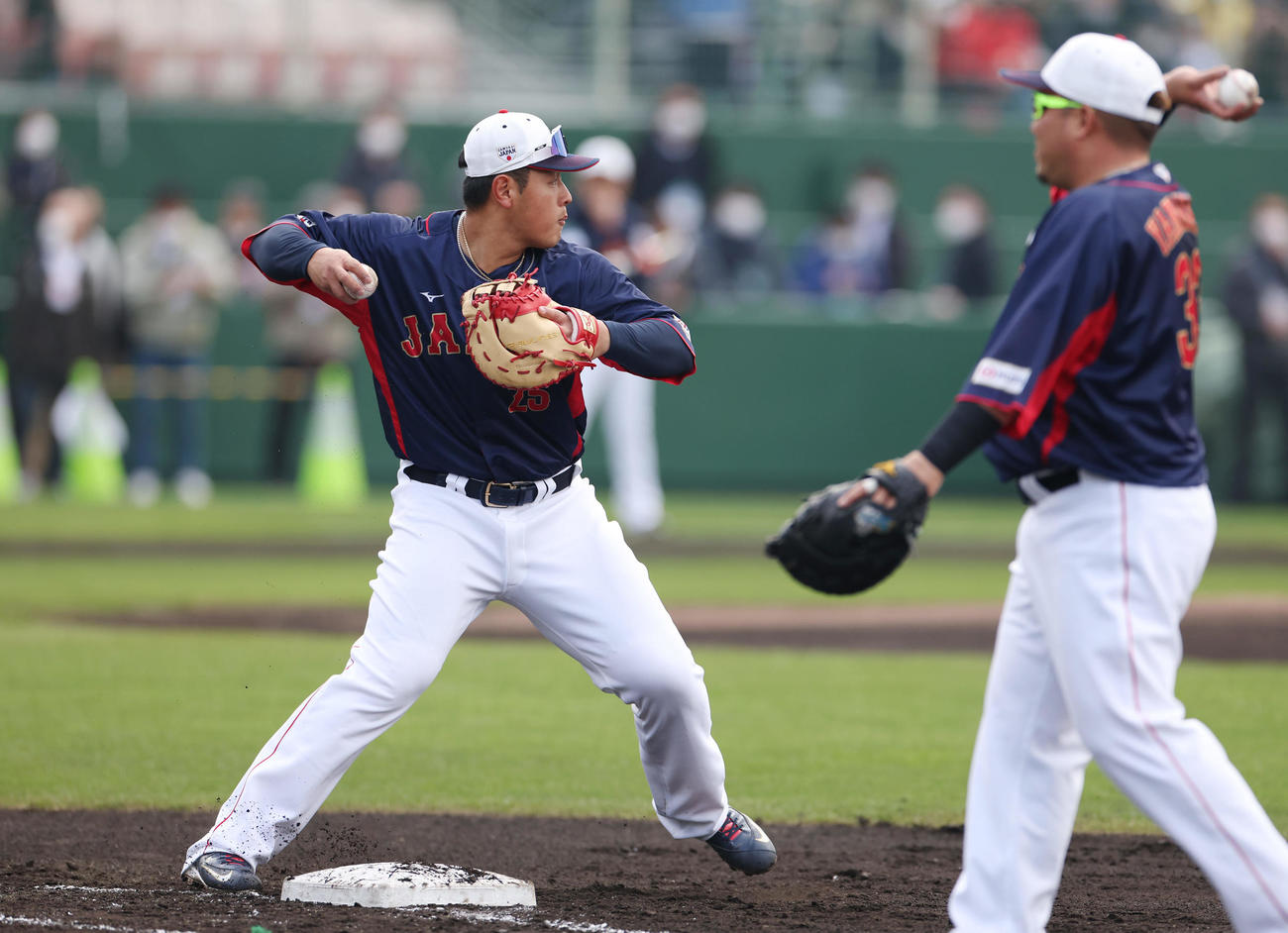 一塁でシートノックを受ける岡本。右は山川（撮影・前田充）