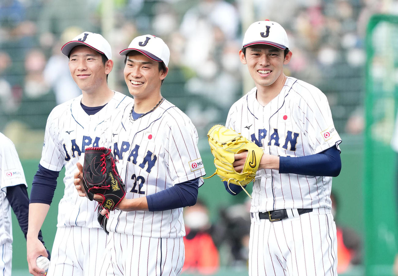 投内連係の練習中に笑顔を見せる、左から戸郷、湯浅、佐々木（撮影・菅敏）