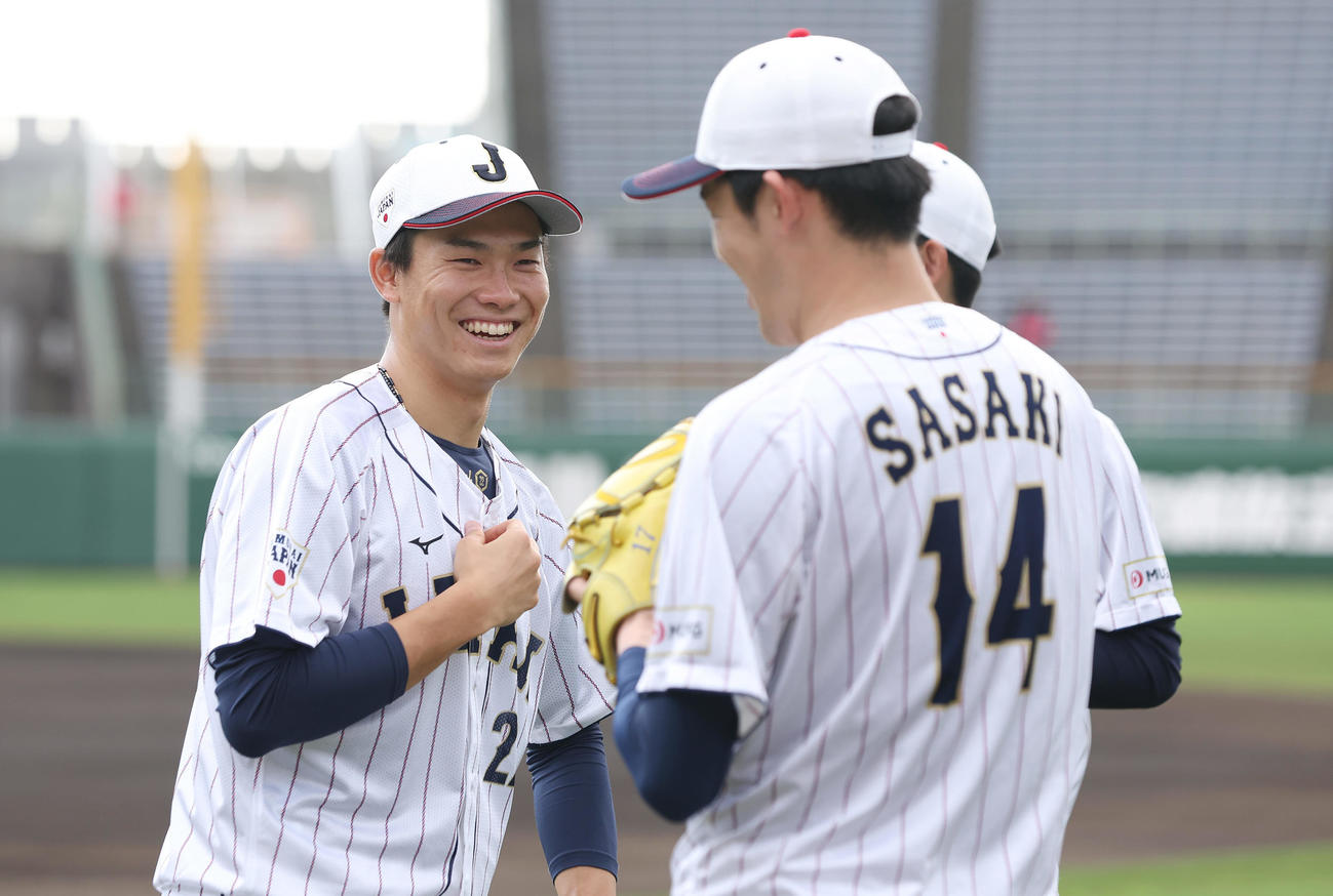 練習前、佐々木（右）と言葉を交わし笑顔を見せる湯浅（撮影・前田充）