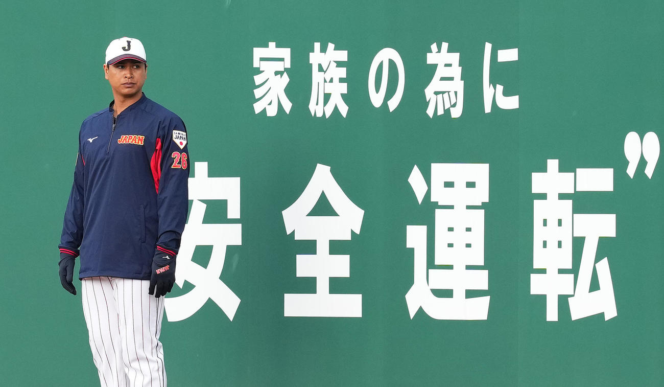 フェンスに張られた「安全運転」の文字を背にする宇田川（撮影・菅敏）
