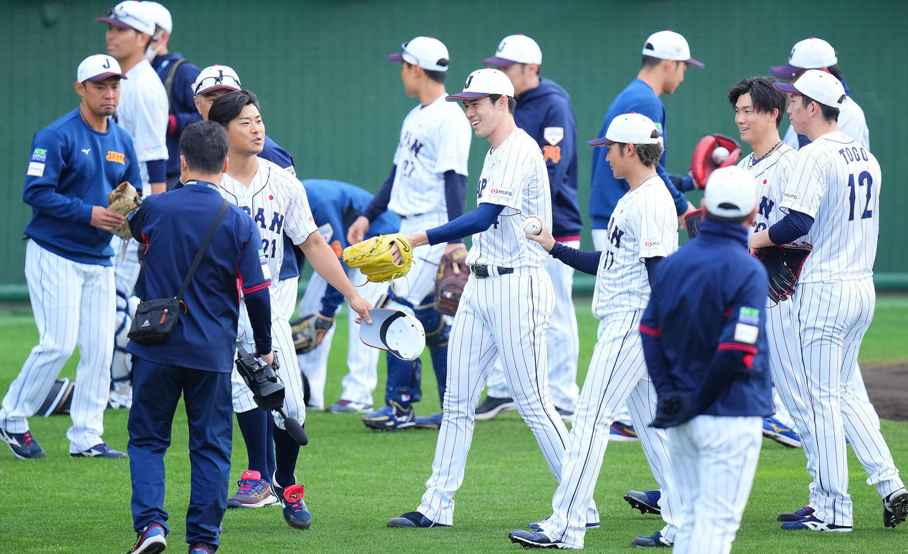 投内連係を終え笑顔を見せる佐々木（中央）（撮影・垰建太）