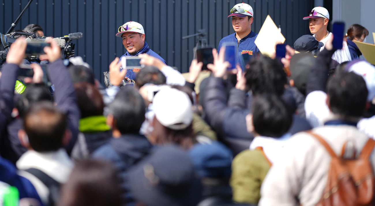 移動中、大勢のファンに声をかけられる、後方左から山川、村上、岡本（撮影・垰建太）