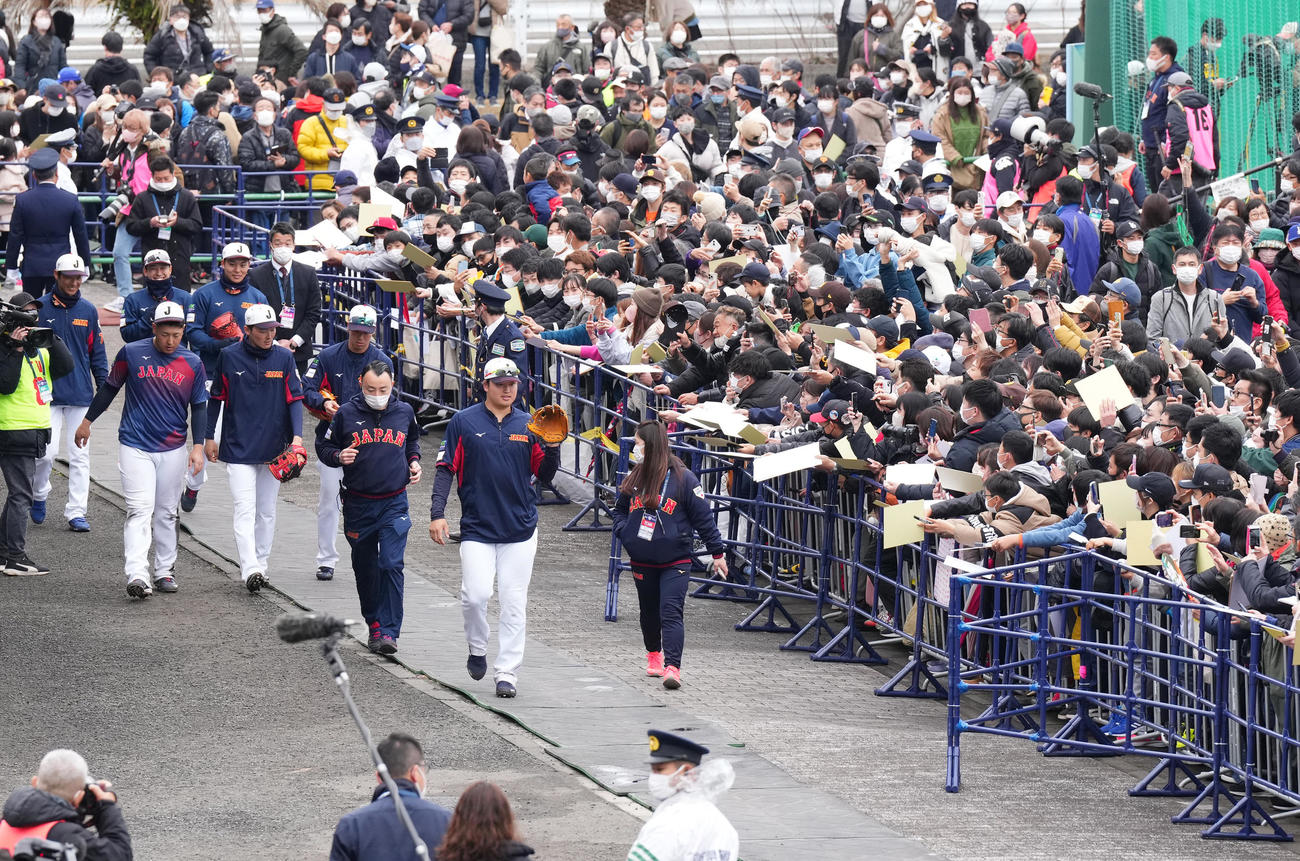 集まった大勢のファンからの声援を受けながら施設を移動する村上（中央）ら（撮影・菅敏）