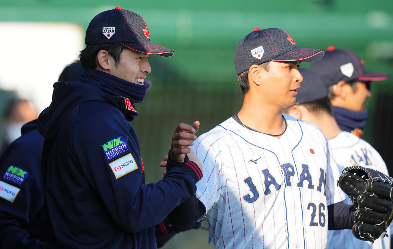 日本対ソフトバンク　7回表ソフトバンク2死一、三塁、後続を抑えた宇田川（右）と笑顔でタッチを交わす佐々木（撮影・垰建太）