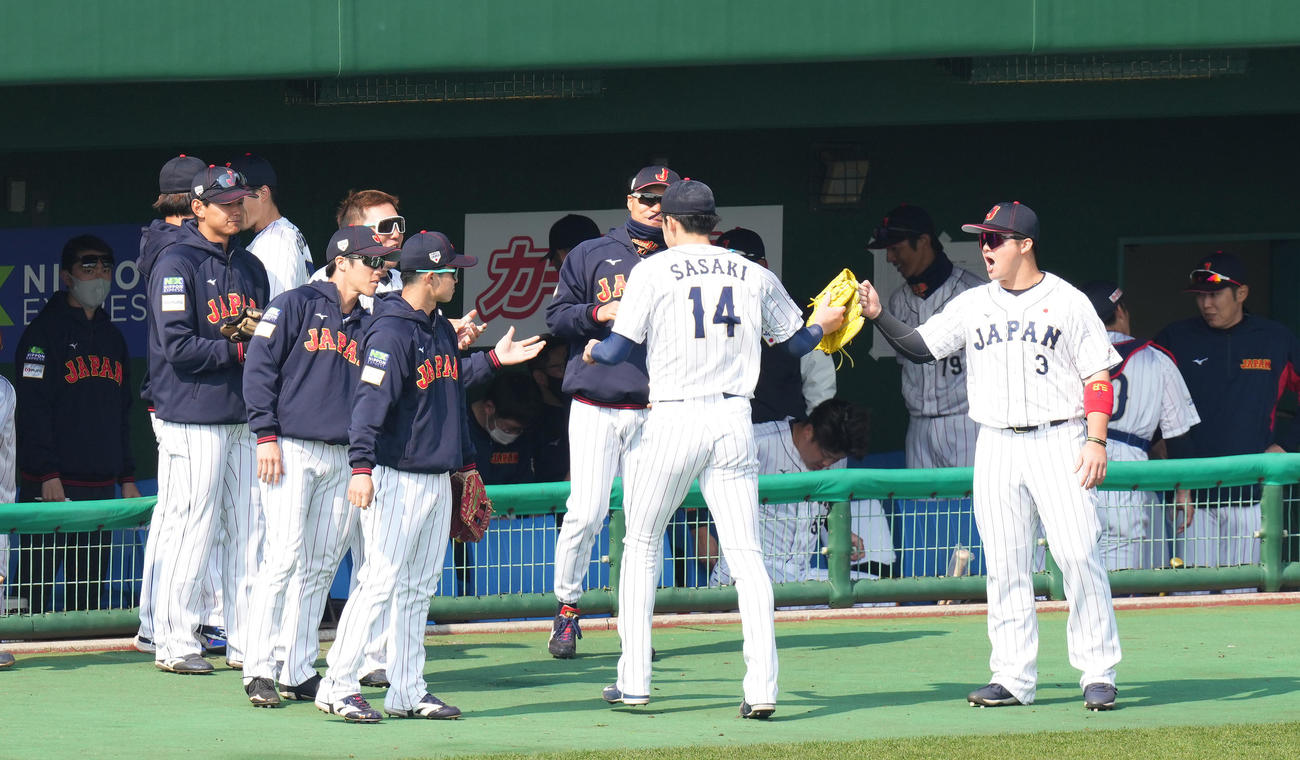 侍ジャパン対ソフトバンク　登板を終え、ナインにタッチで迎えられる佐々木（中央）（撮影・菅敏）