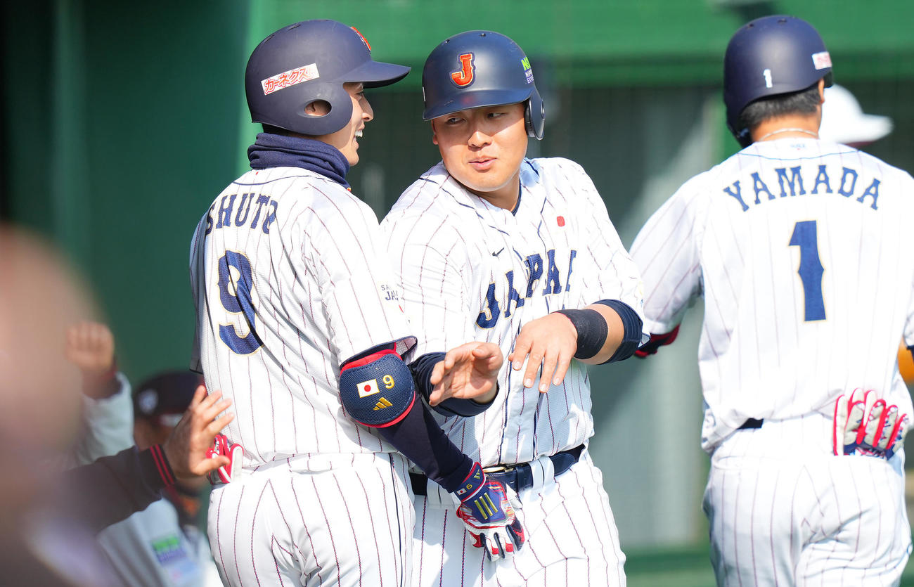 日本対ソフトバンク　4回裏日本1死三塁、周東（左）の遊ゴロの間に生還しナインの出迎えを受ける岡本（中央）（撮影・垰建太）