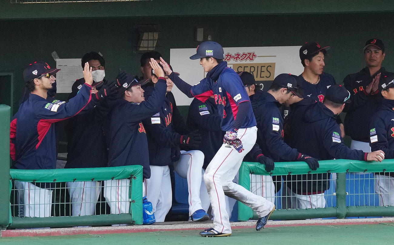 侍ジャパン対ソフトバンク　9回表侍ジャパン1死三塁、源田の勝ち越しの適時打で生還し、ナインにタッチで迎えられる周東（中央）（撮影・菅敏）