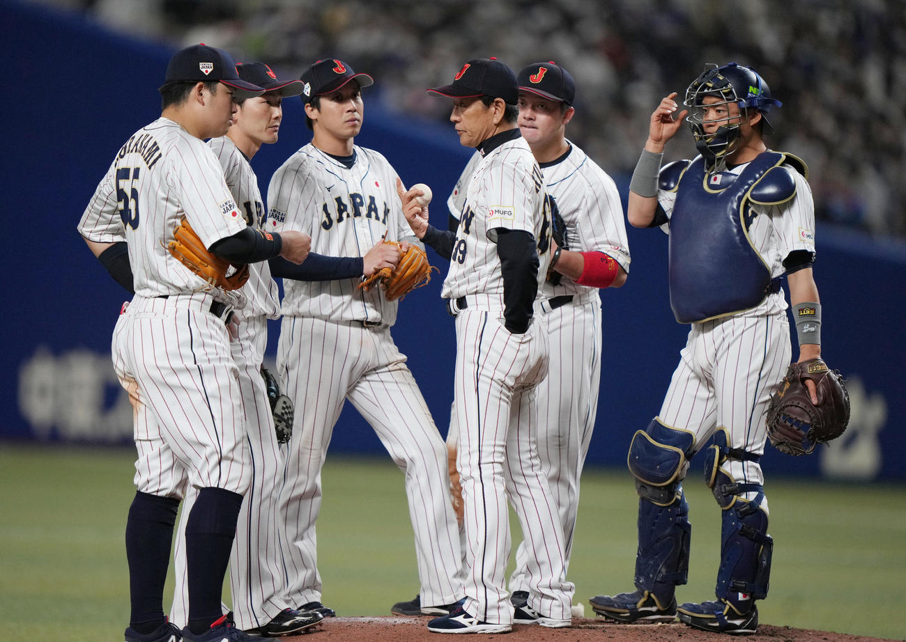 侍ジャパン対中日　7回表途中、交代する栗林を待つ間、村上（左）ら内野陣と話をする栗山監督（中央）（撮影・狩俣裕三）