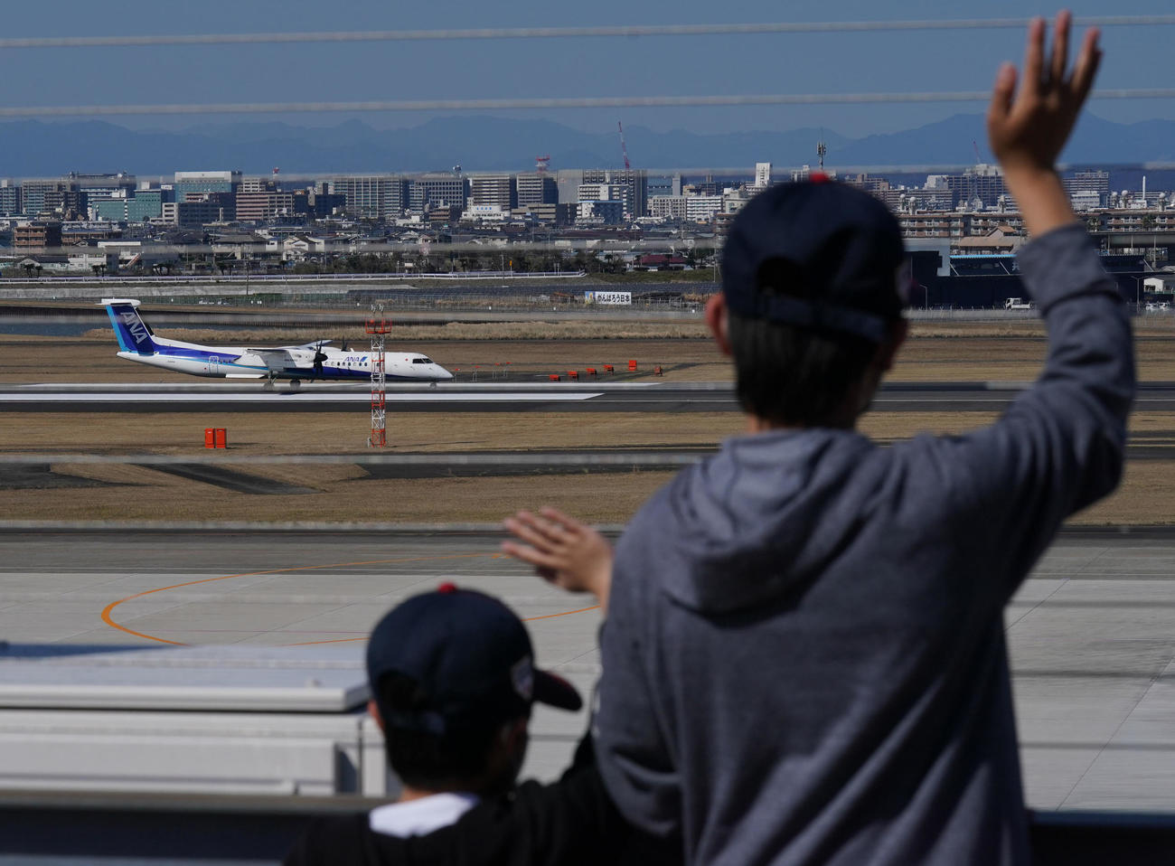 宮崎空港を離陸する侍ジャパンを乗せた飛行機。手を振ってエールを送るファンの姿があった（撮影・垰建太）