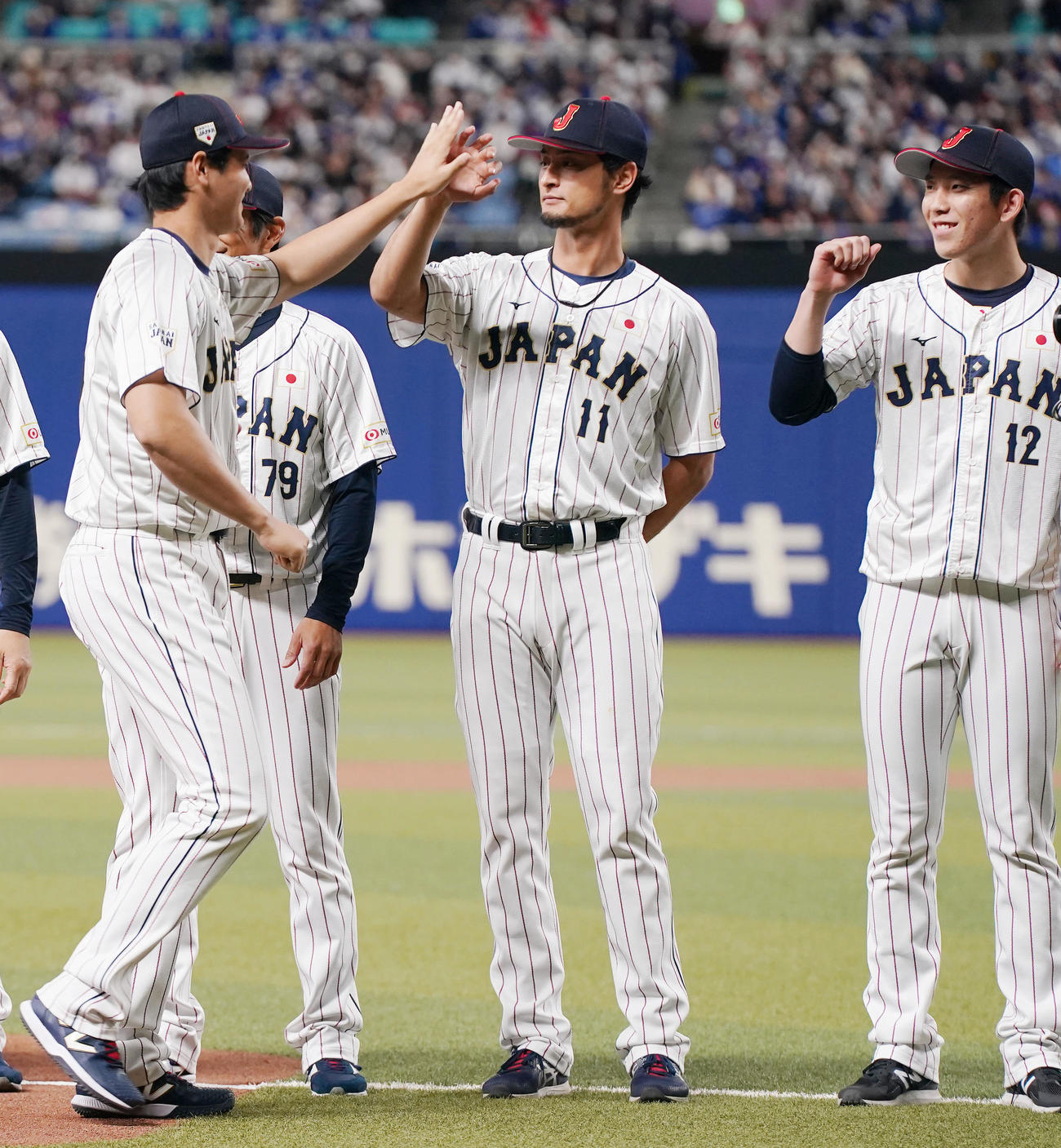 侍ジャパン対中日　試合前セレモニーの選手紹介で、ダルビッシュ有（中央）とタッチを交わす大谷（左）。右は戸郷（撮影・狩俣裕三）