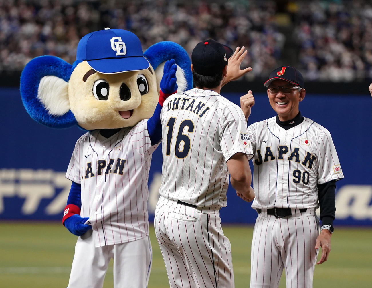 侍ジャパン対中日　試合前セレモニーの選手紹介でドアラをスルーする大谷（手前）。右は白井ヘッドコーチ（撮影・狩俣裕三）