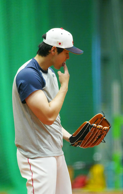 投球練習中、指を湿らせる大谷（撮影・江口和貴）