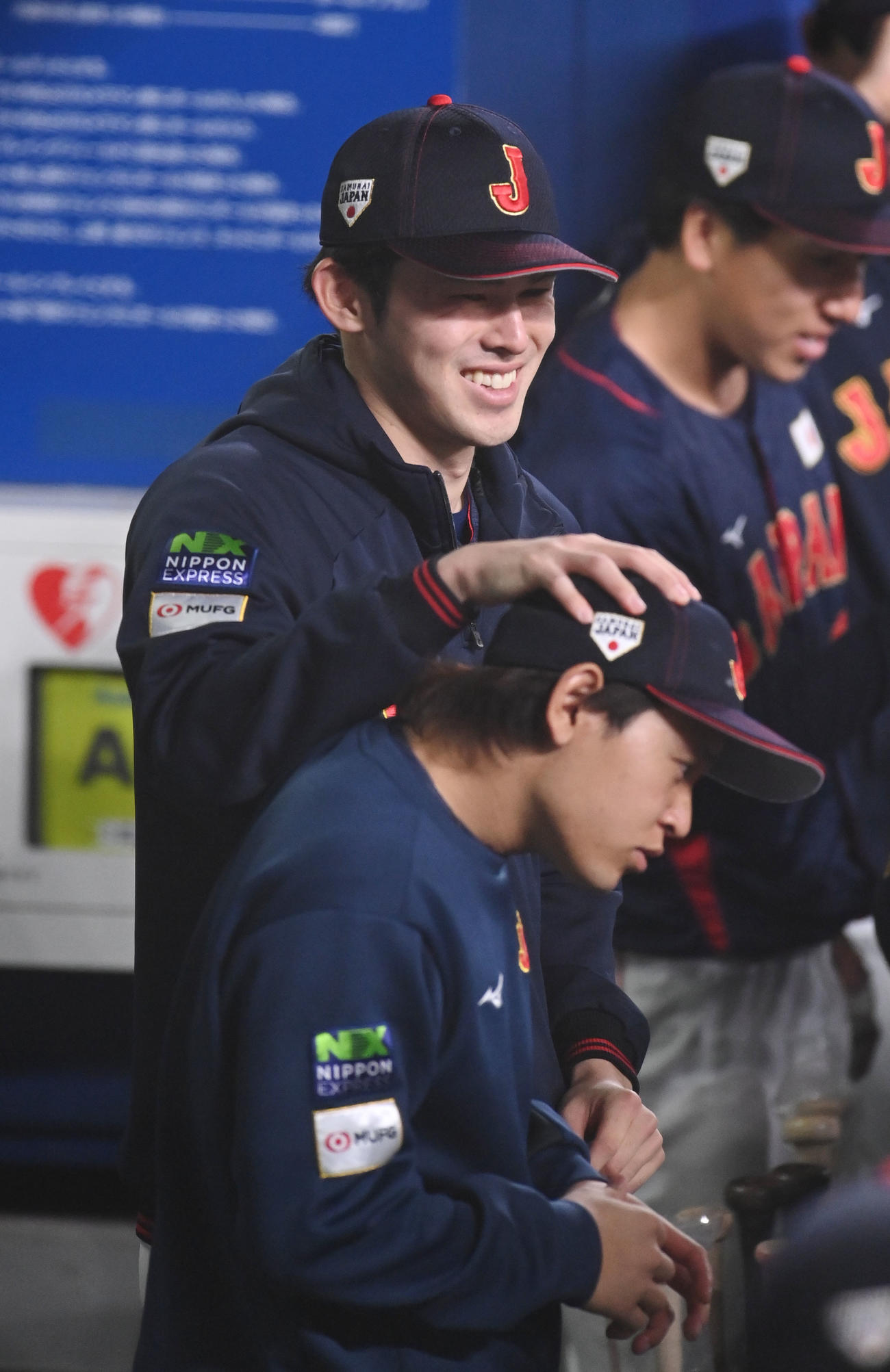 中日対侍ジャパン　ベンチで宮城の頭をグリグリし笑顔を見せる佐々木（撮影・森本幸一）