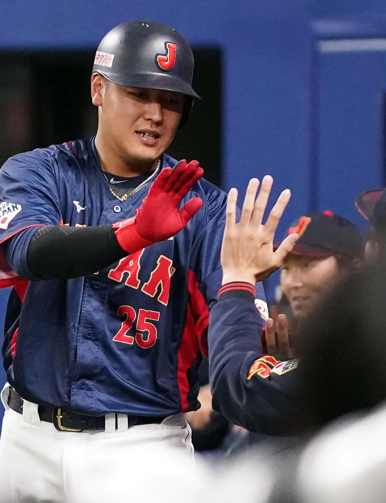 中日対侍ジャパン　7回表侍ジャパン無死、ソロ本塁打を放ち、チームメートに迎えられる岡本（撮影・狩俣裕三）