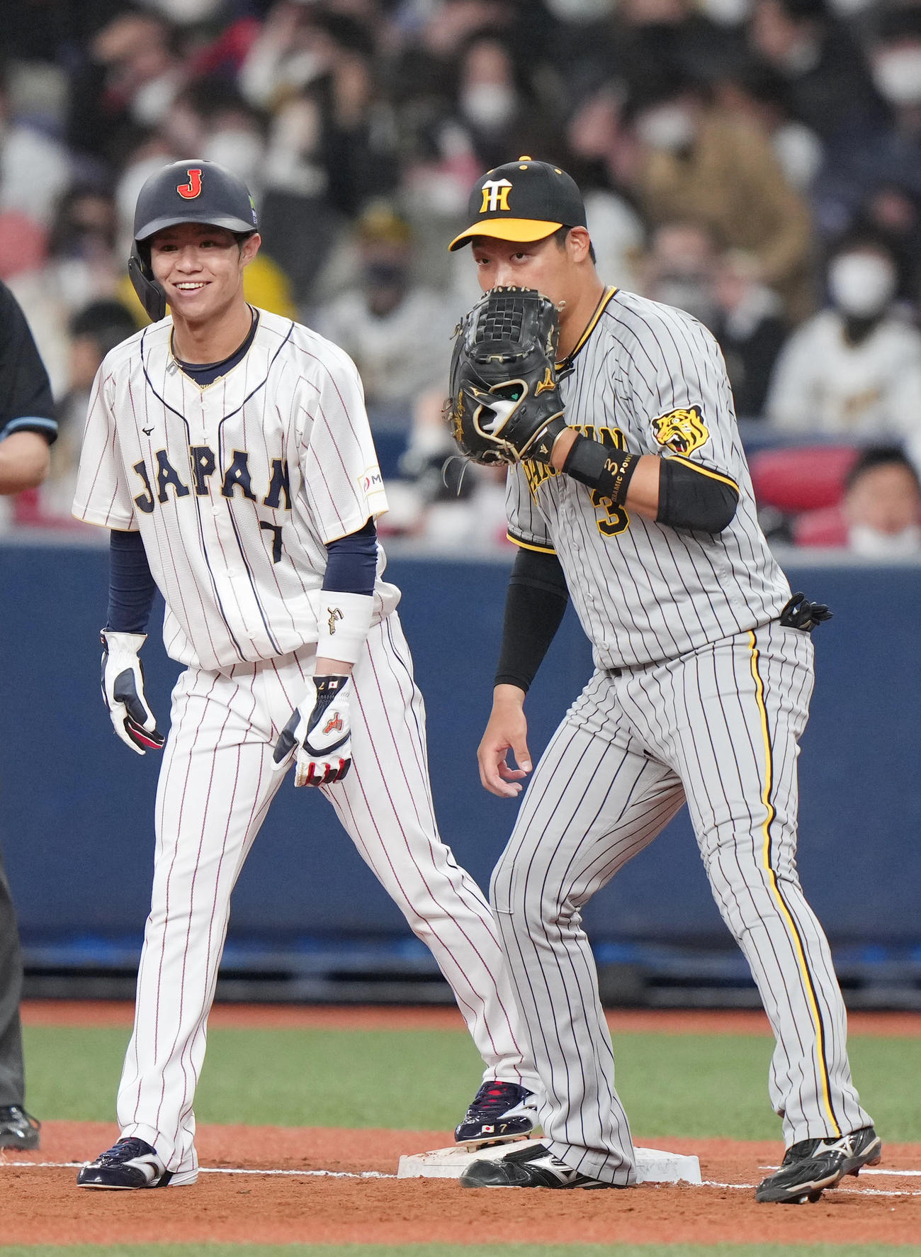 阪神対侍ジャパン　6回表侍ジャパン無死一塁、一塁手大山（右）と笑顔で言葉を交わす代走の中野（撮影・狩俣裕三）