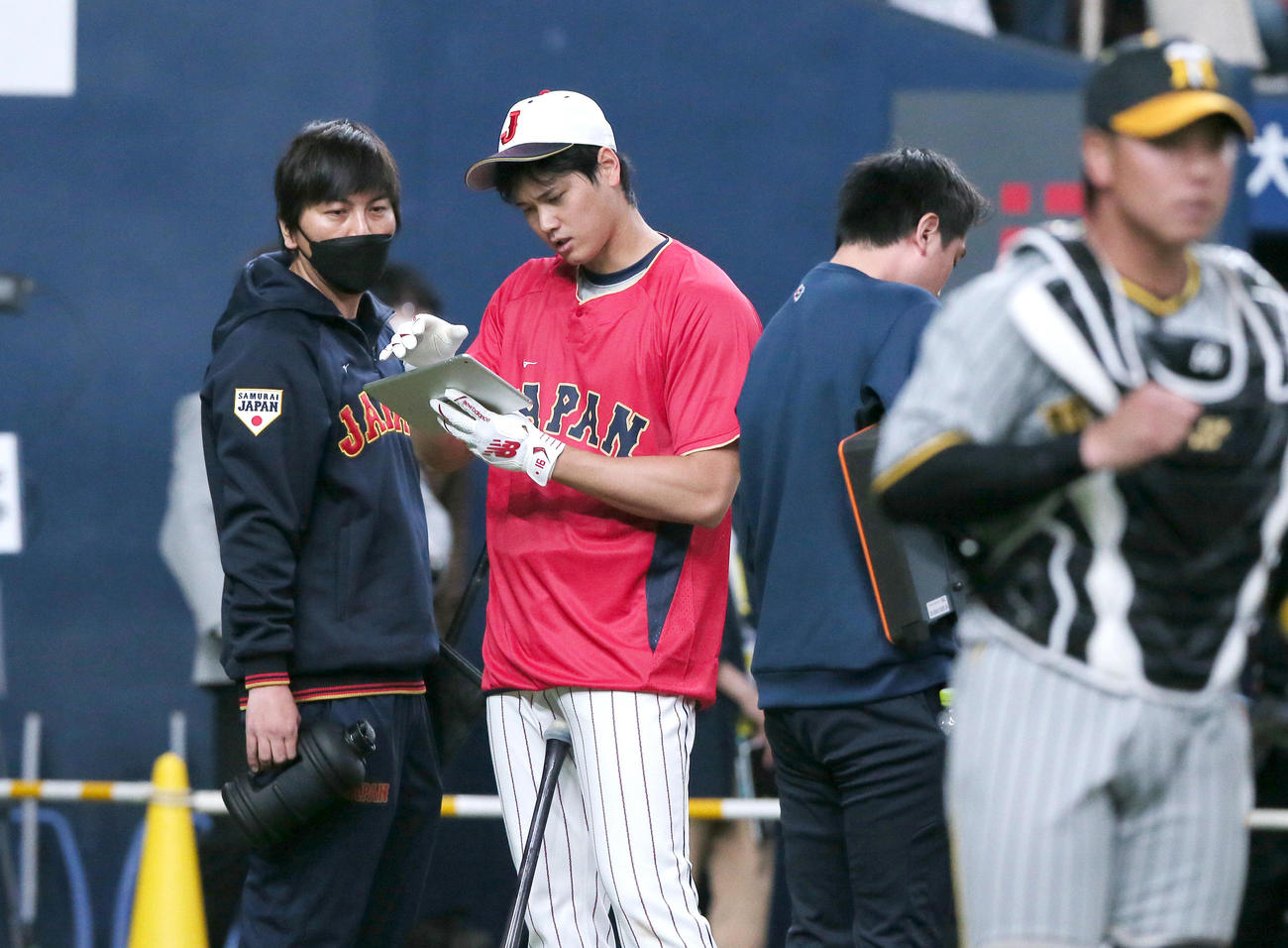 阪神対侍ジャパン　試合前の打撃練習を終えタブレットを見る大谷。左は水原通訳（撮影・上山淳一）