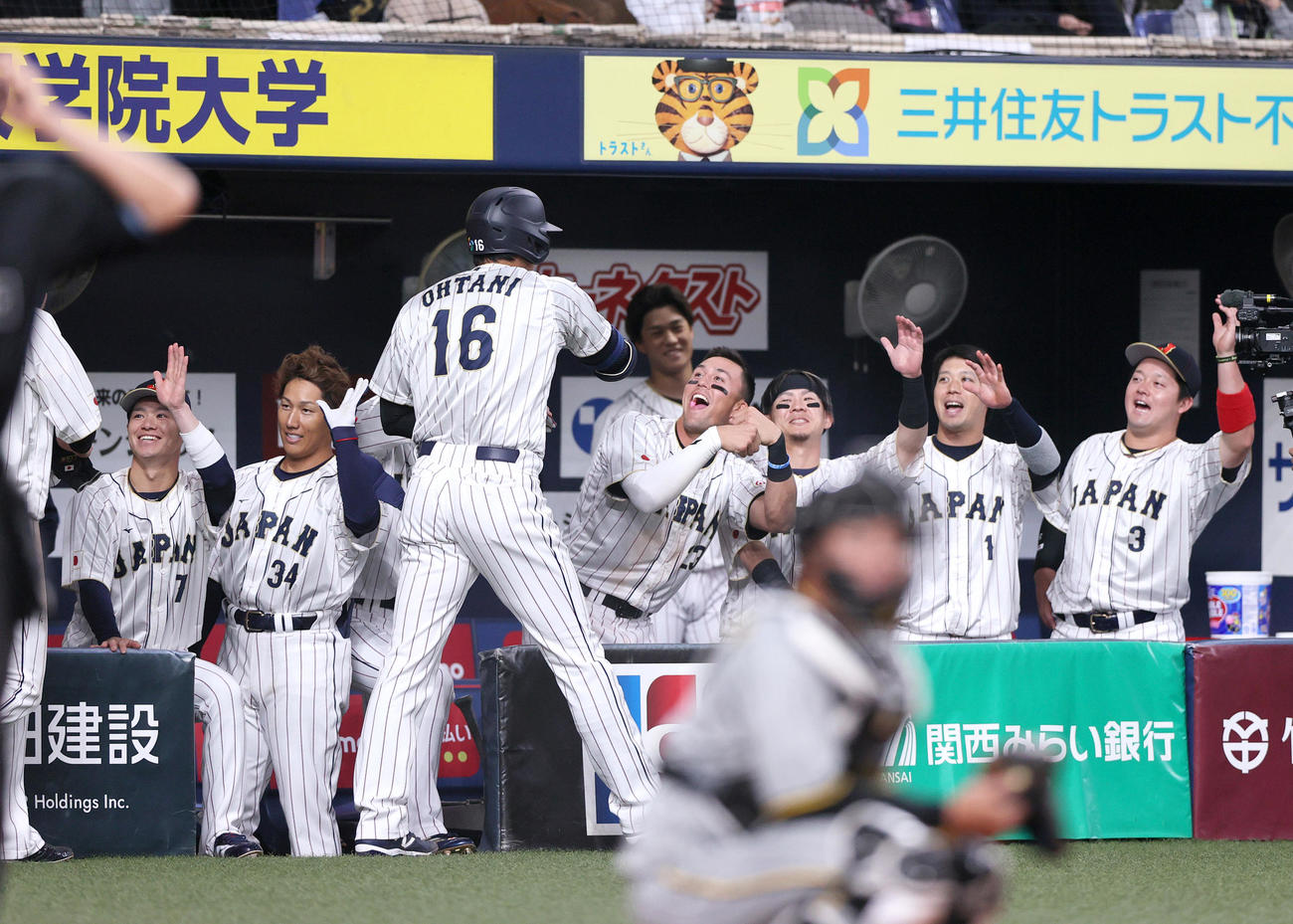 阪神対侍ジャパン　6回表侍ジャパン2死一、二塁、2打席連続3点本塁打を放った大谷（手前）を笑顔で出迎えるナインら（撮影・上山淳一）