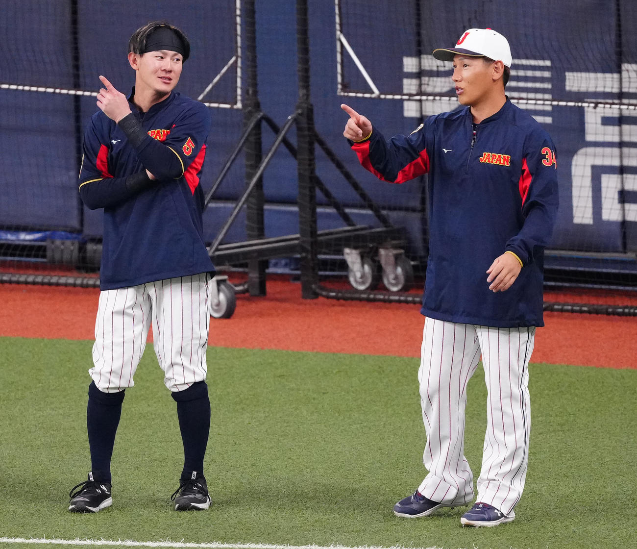 侍ジャパン対阪神　試合前のウオーミングアップ中、言葉を交わす牧原（左）と吉田（撮影・江口和貴）