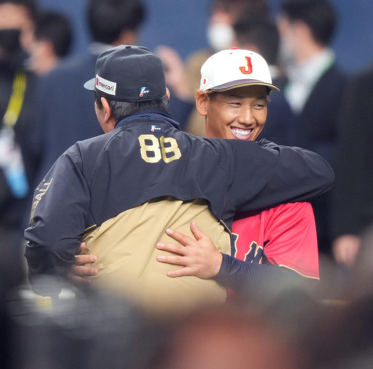 オリックス対侍ジャパン　試合前、オリックス水本コーチ（手前）とハグする吉田（撮影・狩俣裕三）
