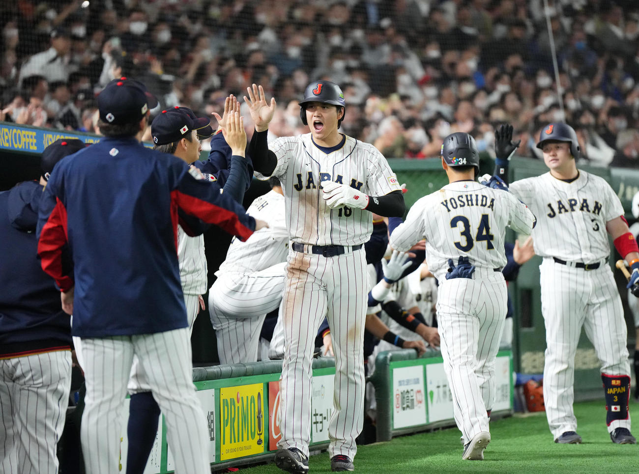 日本対韓国　5回表日本1死三塁、吉田（右から2人目）の右犠飛で三塁から生還し、ナインにタッチで迎えられる大谷（中央）（撮影・菅敏）