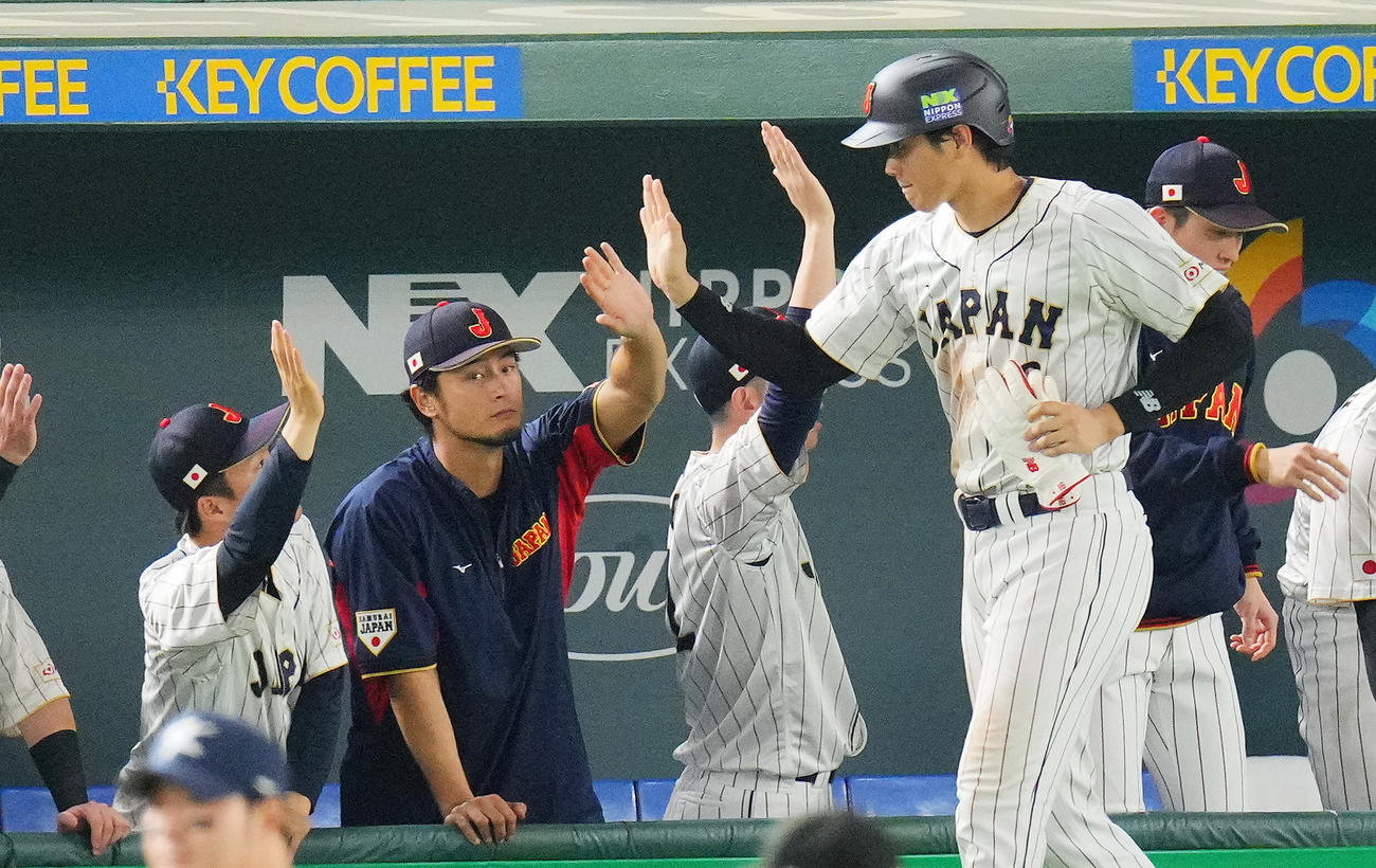 日本対韓国　6回裏日本1死一、二塁、岡本の適時打で生還した大谷（右）とタッチを交わすダルビッシュ（撮影・垰建太）