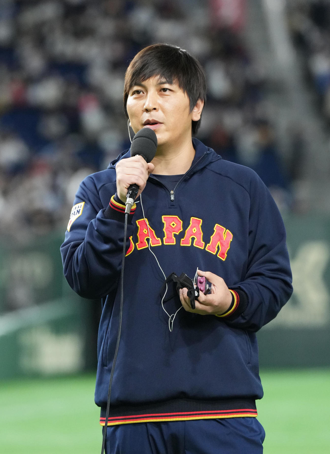 10日、ヒーローインタビューを受けるヌートバーの通訳をする水原氏（撮影・菅敏）