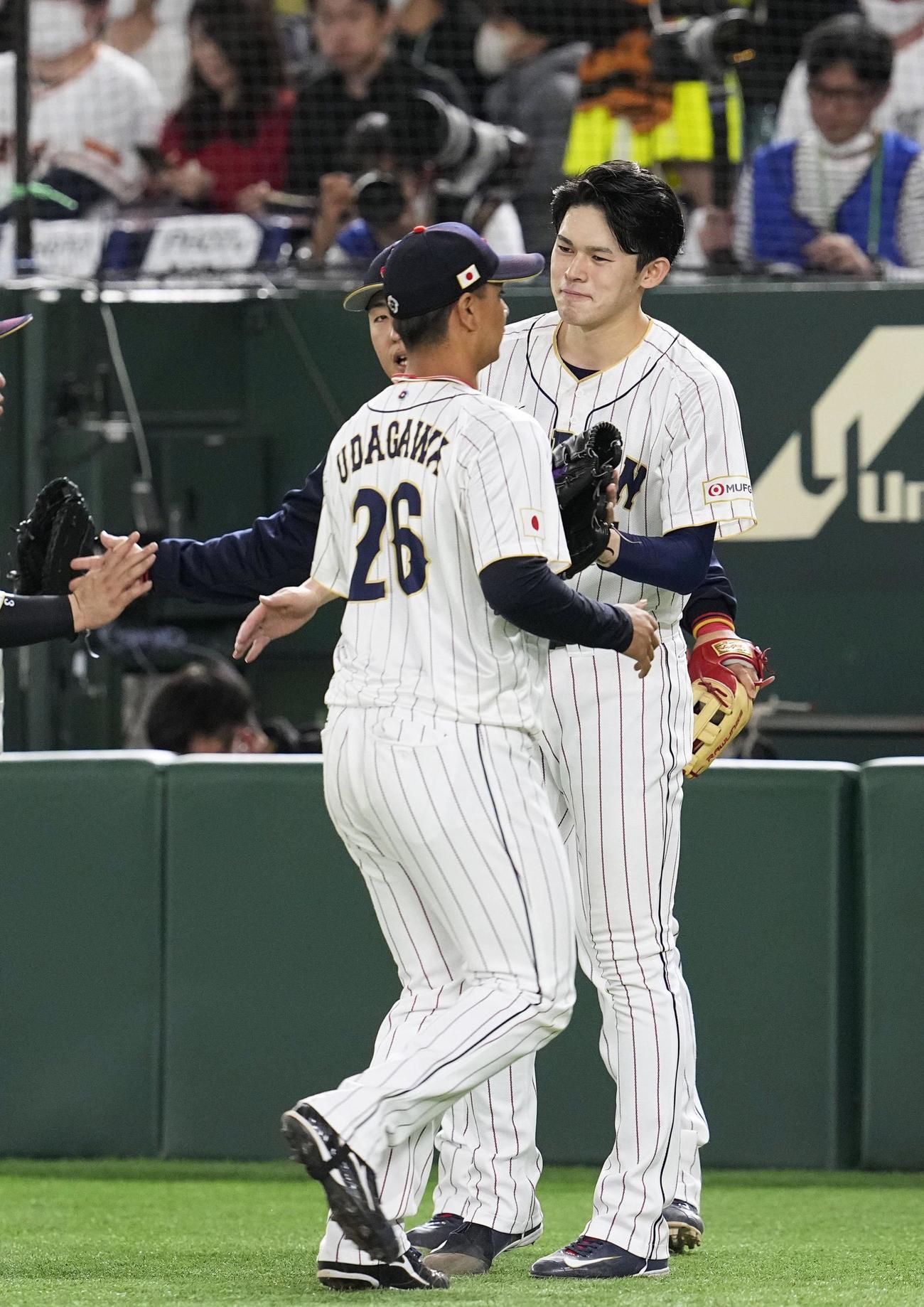 4回の守備を終え、この回の途中からリリーフした宇田川（左）を迎える先発の佐々木朗（共同）