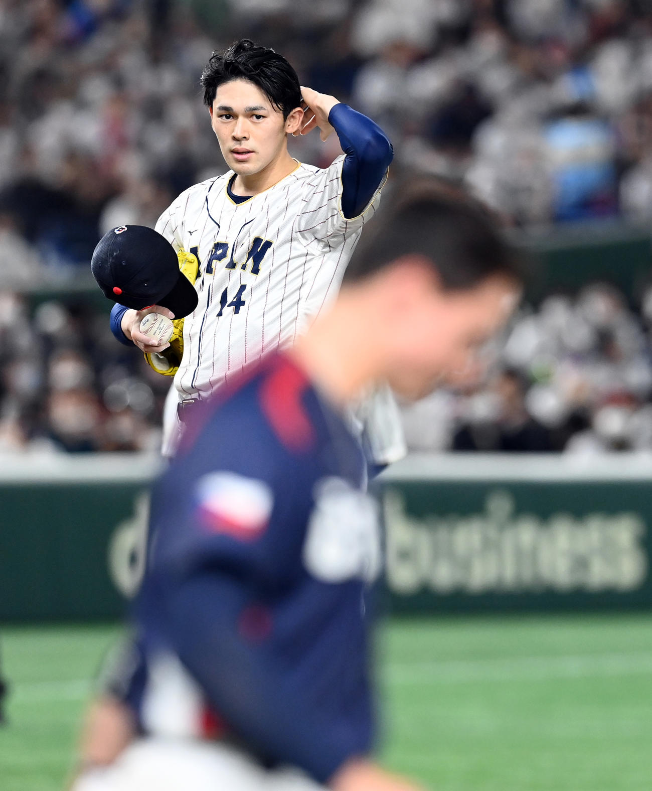 ３月11日、チェコのエスカラ（手前）に死球を与え帽子をとって謝る佐々木