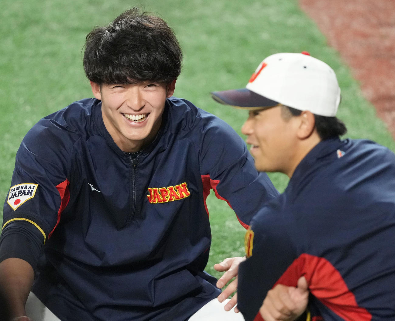 チームに合流し、今永（右）と談笑する山崎（撮影・狩俣裕三）