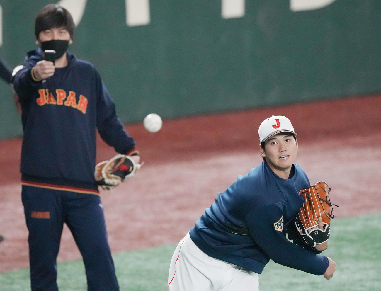 公式練習で水原通訳（左）が撮影する中、キャッチボールで汗を流す大谷（撮影・狩俣裕三）