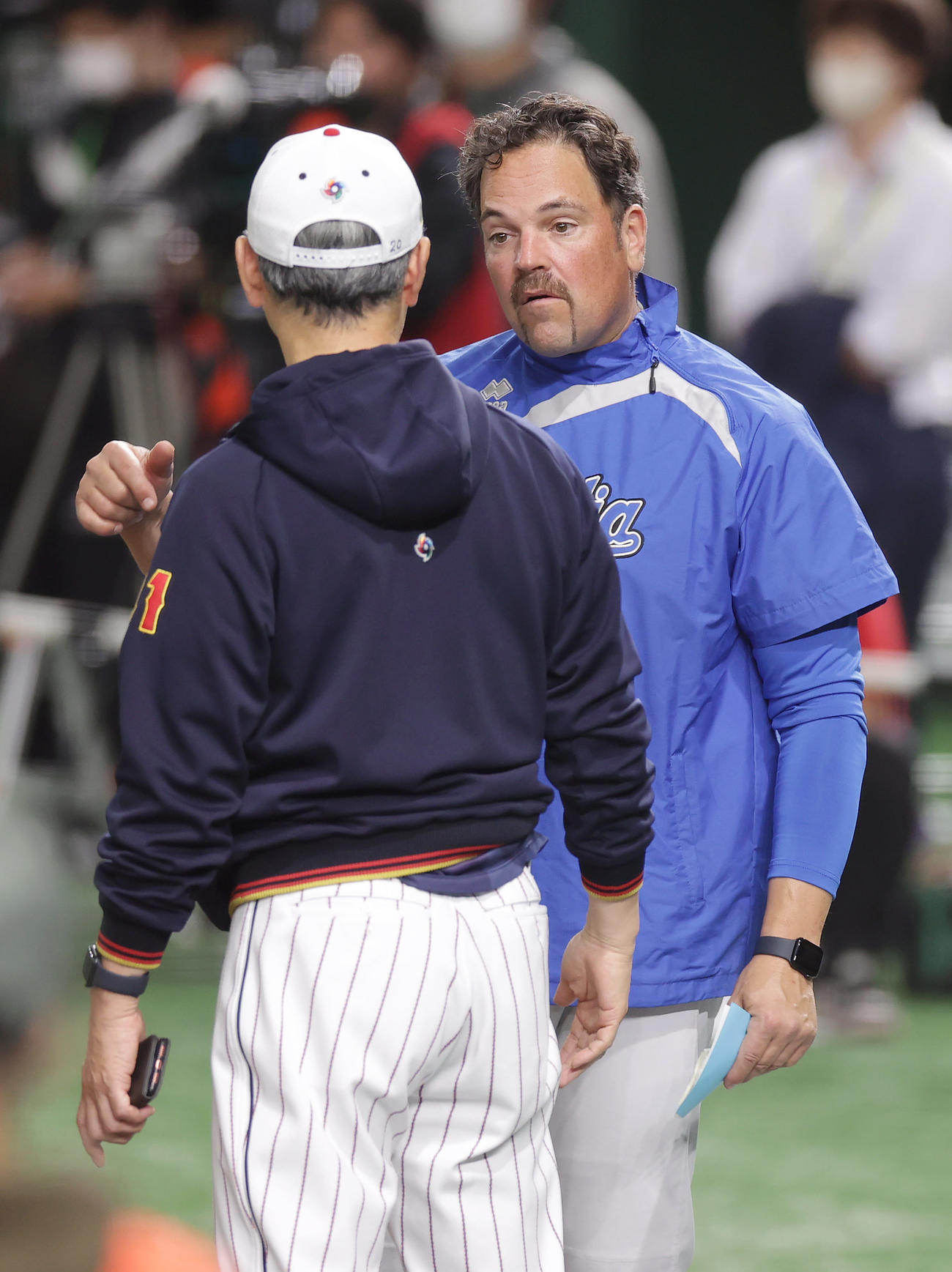 日本対イタリア　試合前練習で吉井投手コーチ（手前）と言葉を交わすイタリアのピアザ監督（撮影・前田充）