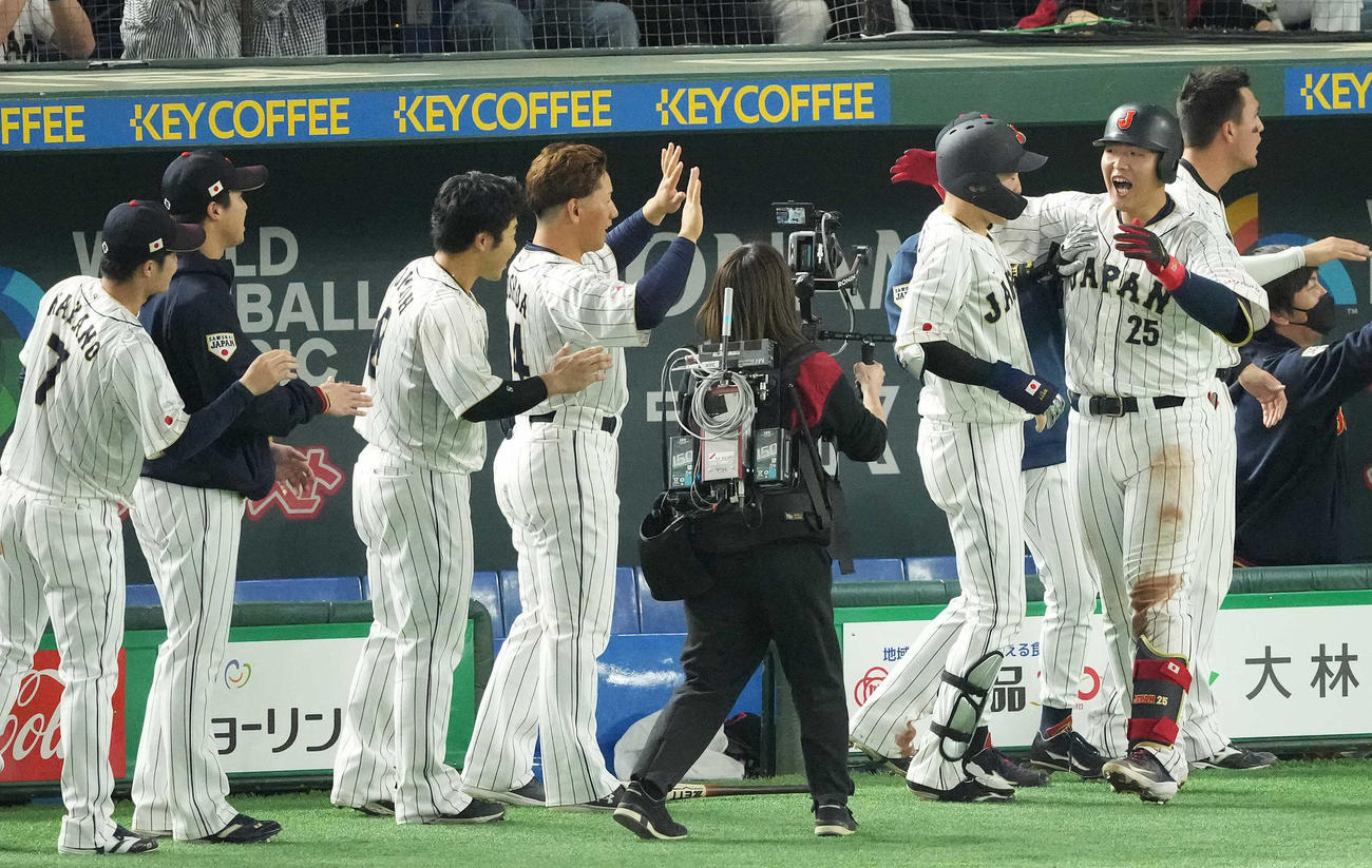日本対イタリア　3回裏日本2死一、二塁、左越え3点本塁打を放った岡本（右）はナインと笑顔でハイタッチ（撮影・鈴木みどり）