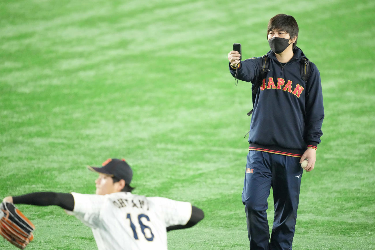 日本対イタリア　試合前、大谷のアップを見守る水原通訳（撮影・鈴木みどり）